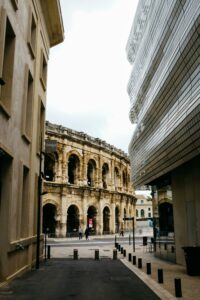Nîmes – Histoire et modernité Centre-ville de Nîmes avec les Arènes et les nouveaux quartiers en arrière-plan, symbole du mélange entre histoire et modernité dans le marché immobilier nîmois.